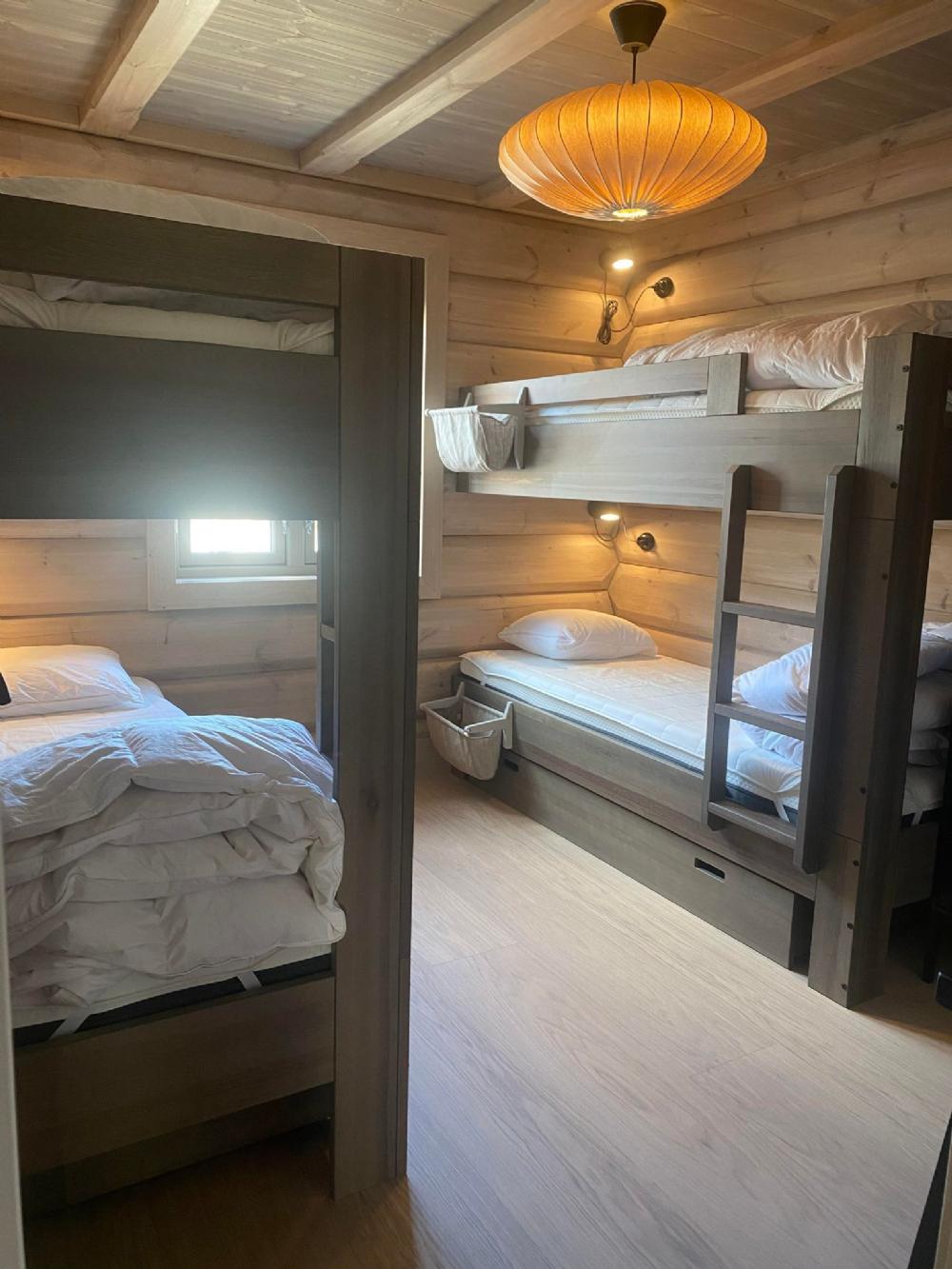 Sov 3: Dubbla våningssängar med garderob i ena hörnet och förvaring under sängarna.